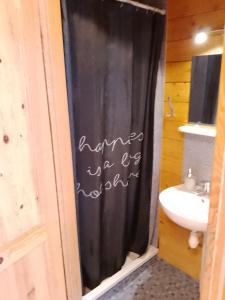 梅尔诺Domki letniskowe Przyczepy kempingowe Zacisze Mielno的浴室设有黑色淋浴帘和水槽