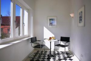 科尔平塞达海姆别墅 - FeWo 01的一间带桌子和两把椅子的用餐室以及窗户。