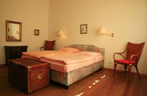 科尔平塞Villa Daheim - FeWo 02的一间卧室配有一张床和一张红色椅子