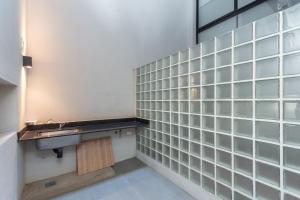 布宜诺斯艾利斯Live Soho Boutique & Apartments Palermo Hollywood的一间带水槽和玻璃瓷砖墙壁的浴室
