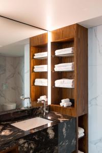 奥克兰Horizon by SkyCity的浴室配有盥洗盆和带毛巾的台面。