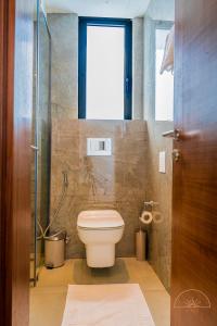 阿克拉SOLEA - Super central, comfortable and modern apartment的一间带卫生间和玻璃淋浴间的浴室