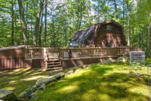 杜波依斯Family-Friendly DuBois Cabin with Community Pool!的树林中的小木屋,带甲板和房子