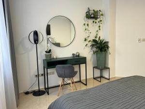 布拉迪斯拉发LEO Apartment FREE PARKING - President Palace的一间卧室配有书桌、镜子和椅子