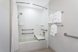 克里斯特尔里弗水晶河快捷假日酒店的一间带白色毛巾和淋浴的浴室