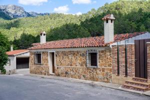 耶斯特Casa rural Mirador del Río Tus, en Yeste的石头建筑,上面有两个烟 ⁇ 