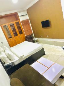伊凯贾Posh Hotel and Suites Ikeja的一间卧室配有两张床和一台平面电视