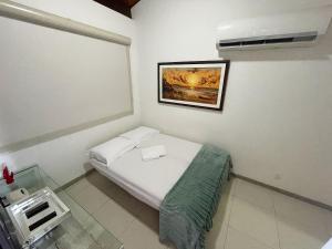 嘎林海斯港Flat Duplex - Muro Alto Malawí的小房间,配有一张床,墙上挂着一张照片