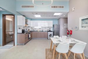 迪拜Trinity Holiday Homes - Spacious Modern Living 2BR Unique Apartment的厨房配有白色的桌子和白色的椅子