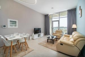 迪拜Trinity Holiday Homes - Spacious Modern Living 2BR Unique Apartment的带沙发和桌子的客厅以及用餐室