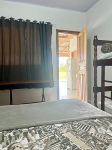 南圣弗朗西斯科Recanto Monte Trigo的一间卧室配有床和带窗帘的窗户