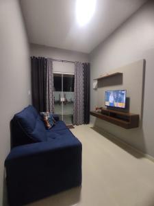 圣阿马鲁Dunas residence casa 15- Lençois Maranhense的客厅配有蓝色的沙发和平面电视。