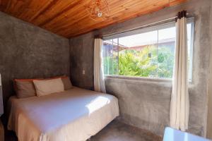 戈亚斯州上帕莱索Vita Chalés, na avenida central的一间卧室设有一张床和一个窗口