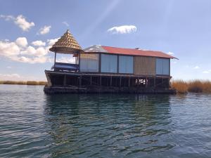 普诺Titicaca Magical Lodge Peru的水面上码头上的房屋