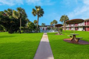 维洛海滩Red Roof Inn Vero Beach - I-95的一条穿过公园的小径,公园里拥有两张野餐桌和棕榈树