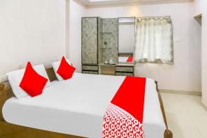 维沙卡帕特南OYO Flagship 81201 Sls Luxury Suites的卧室配有带红色枕头的大型白色床