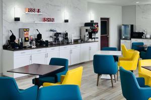 威斯敏斯特Comfort Suites Denver North - Westminster的一间设有黄色和蓝色椅子和桌子的等候室