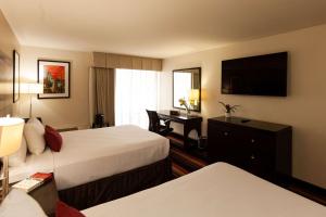 肯纳Clarion Hotel New Orleans - Airport & Conference Center的酒店客房配有两张床和一张书桌