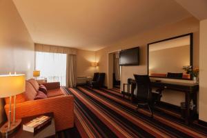 肯纳Clarion Hotel New Orleans - Airport & Conference Center的带沙发和书桌的酒店客房