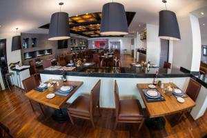 墨西哥城里亚索机场酒店的一间带木桌椅的餐厅和一间酒吧