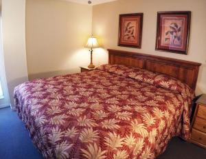 圣徒皮特海滩Island Gulf Resort, a VRI resort的一间卧室配有一张大床和红色的被子