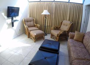 圣徒皮特海滩Island Gulf Resort, a VRI resort的客厅配有沙发、椅子和电视