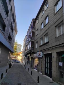 坎巴多斯Fogar San Sadurniño的城市中一条空荡荡的街道,有建筑