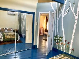 巴港3 Bedroom 2 Bath Carriage House (Pet Friendly)的一间卧室配有一张床,一扇门配有树壁画