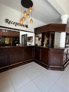 费德拉西翁拉卡索纳酒店的一间设有木制橱柜的房间和一个可读到接待处的标志