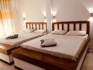 达瓦拉维Wild Eagle Safari Resort的白色墙壁客房中的两张单人床