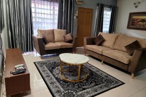 Bandar Baru BangiHomestay FourSeasons @ Bandar Baru Bangi的客厅配有两张沙发和一张咖啡桌