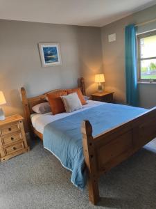 基拉尼Old Killarney的一间卧室配有一张大木床和蓝色床单