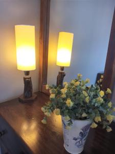 瓜伊马延Rodando x Mendoza的花瓶,桌子上花,有两盏灯