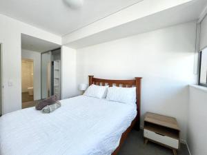 悉尼SkyPark Oasis Retreat 2Br@ close to Olympicpark的卧室配有一张带镜子的白色大床
