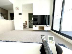 悉尼SkyPark Oasis Retreat 2Br@ close to Olympicpark的客厅桌子上的遥控器