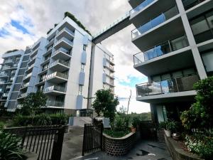 悉尼SkyPark Oasis Retreat 2Br@ close to Olympicpark的一座大型公寓楼,前面设有围栏