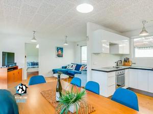 埃利奥特港Retro Groovy Pad Pt Elliot的厨房以及带桌子和蓝色椅子的客厅。
