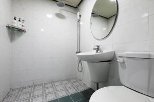 水原市Suwon Hotel Praha的一间带卫生间、水槽和镜子的浴室