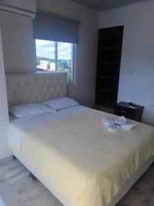 TauramenaHOTEL LA CASONA的卧室配有白色的床,床上有花