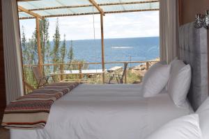 奥科苏尤Allpaluxe Peru Lodge的一间卧室设有一张床,享有海景