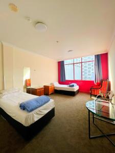奥克兰Fort Street Accommodation的酒店客房,设有两张床和一张玻璃桌