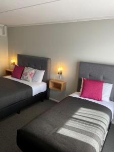 德尼利昆德尼利昆汽车旅馆的酒店的客房 - 带2张带粉红色枕头的床