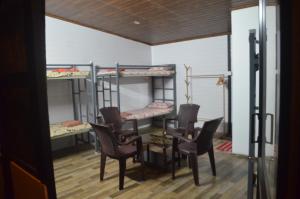 戈德亚姆The Meadows INN的客房设有四张双层床和一张桌子及椅子。