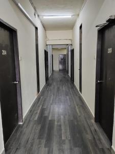 哥打巴鲁Hotel Kenangan的办公室大楼里空空的走廊,铺有木地板