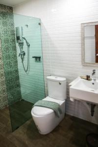 廊开Vera Costa Hotel的浴室配有卫生间、淋浴和盥洗盆。