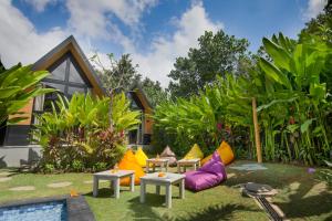 坎古Le Cielo Resort Umalas by Maviba的一座花园,房子前方设有色彩缤纷的家具