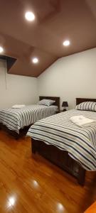 苏克雷Casa Ayacucho的铺有木地板的客房内的两张床