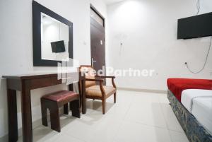 雅加达Hotel Borobudur Kemayoran Syariah Mitra RedDoorz的客厅配有书桌和床。