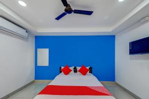 KhandagiriSPOT ON Hotel Utrishree的一间卧室配有一张蓝色墙壁的床