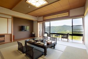 箱根Hakone Ashinoko Bikeikan 箱根芦ノ湖 美景館的一间带桌椅的客厅和一间用餐室